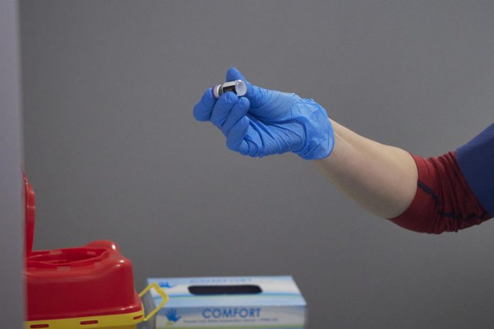Una trabajadora sanitaria manipula el material necesario para administrar la vacuna contra la COVID-19